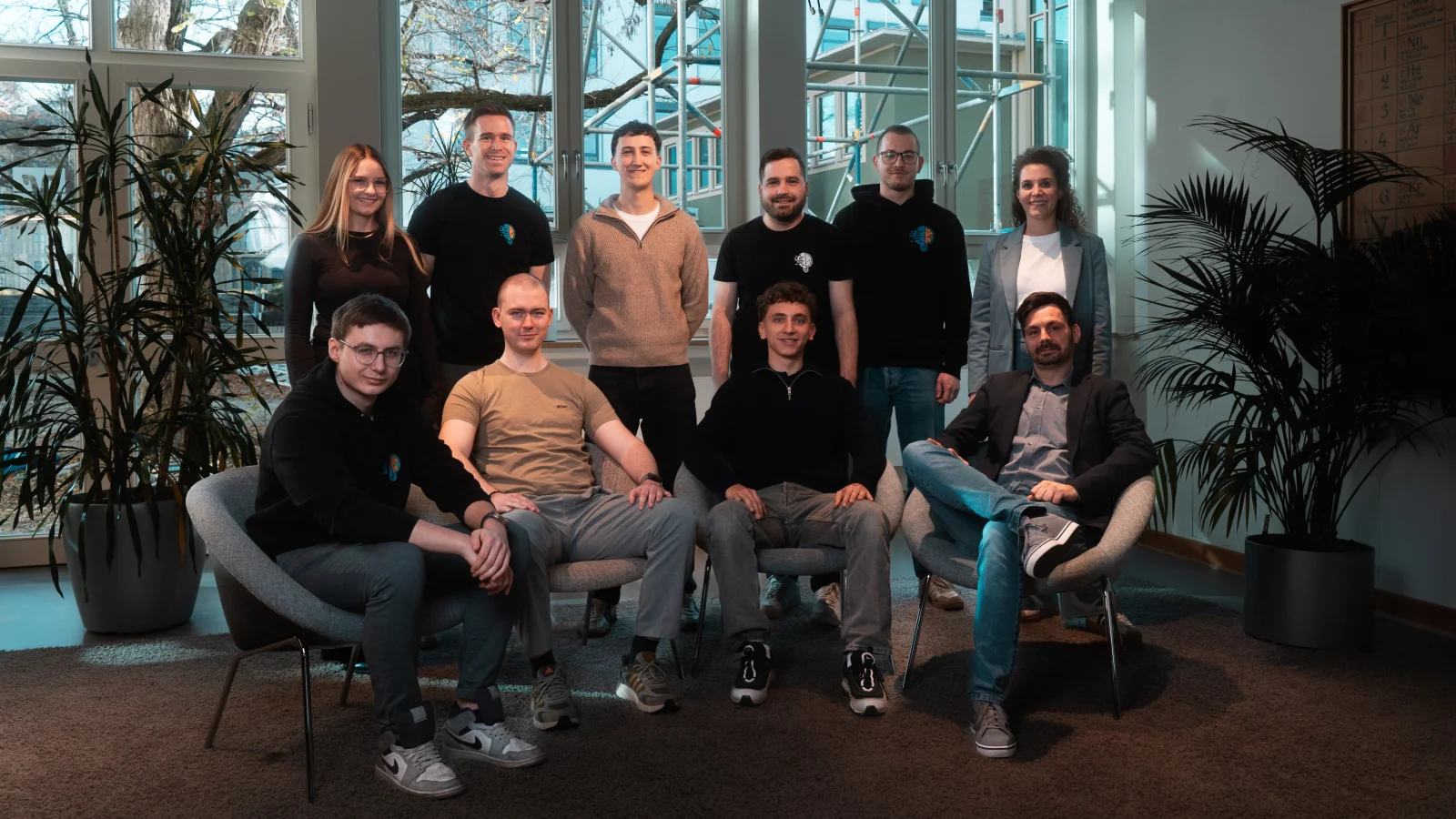 Das ganze InnoBrain Team. Sie stehen und sitzen in einem Halbkreis. Vorne sitzen vier Personen und hintendran stehen sechs Personen.