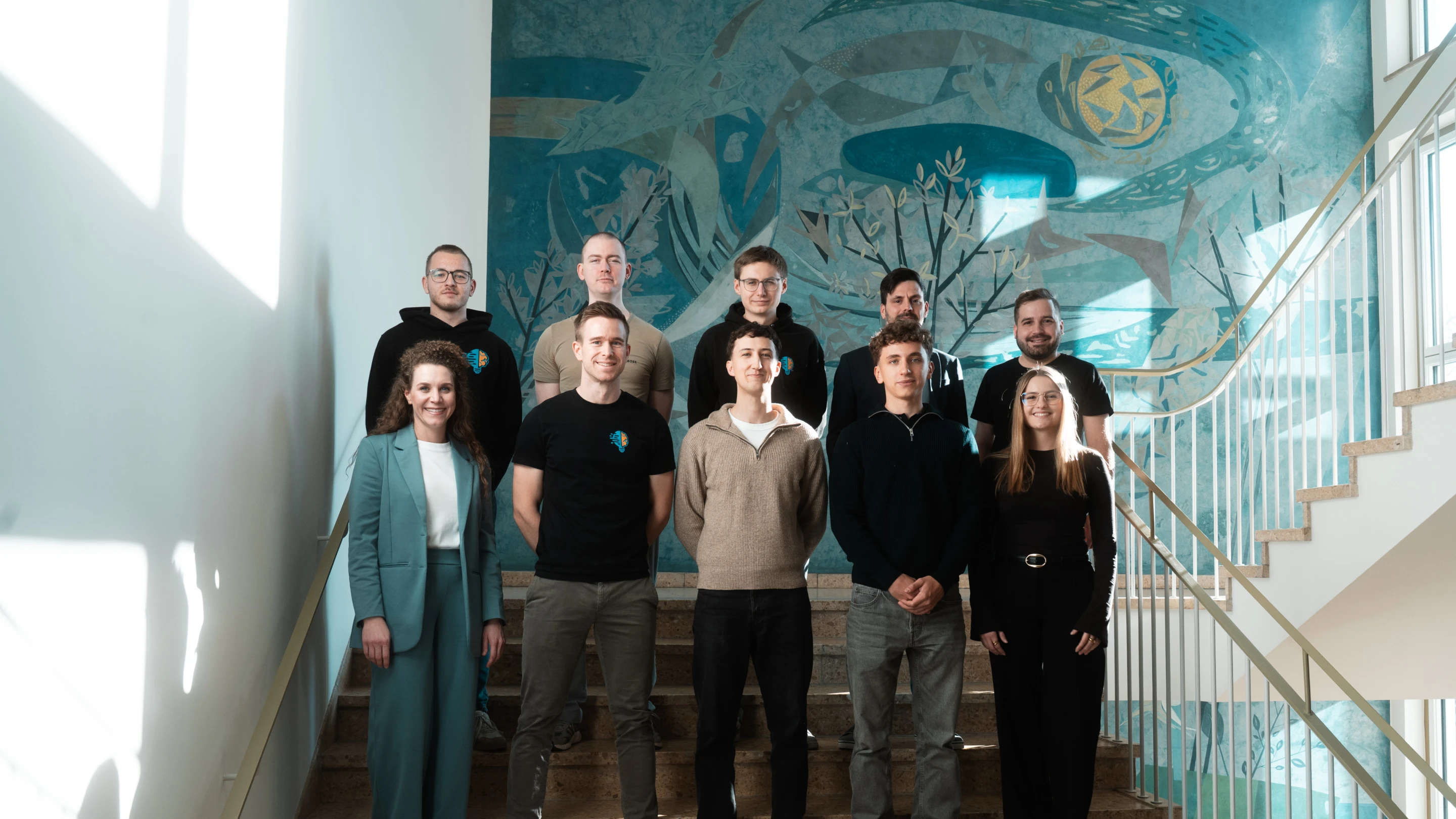 Das Innobrain-Team steht an einer Steintreppe. Alle lächeln außer einer.