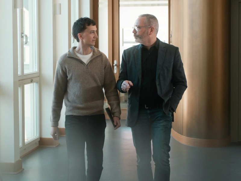 Tobias Reuss mit einem Kunden. Sie laufen einen Gang entlang.